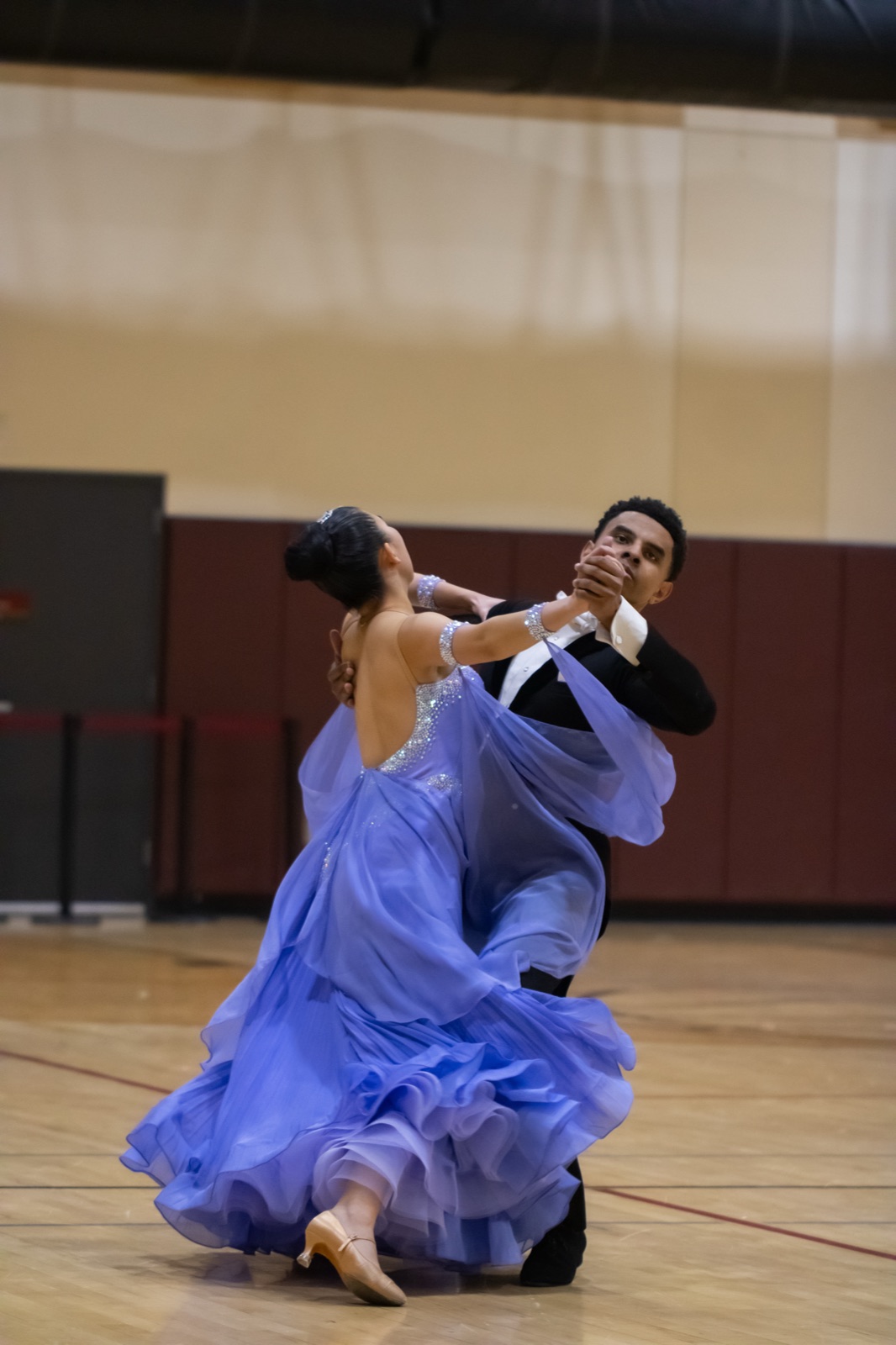 A couple dancing Standard in closed hold, the follower in a pale blue ballgown.